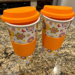 Ceramic mugs with silicone grips and lids.